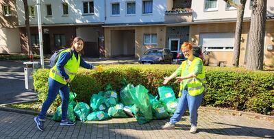 Zwei Aktionsteilnehmerinnen vor ungefähr fünfzehn Müllsäcken