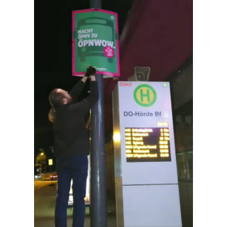 Ein Mitglied eines Plakatierungsteams bringt unser Wahlplakat zum ÖPNV (